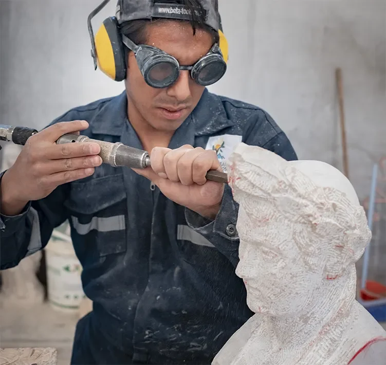 Artigiano delle Ande al lavoro su una scultura in pietra